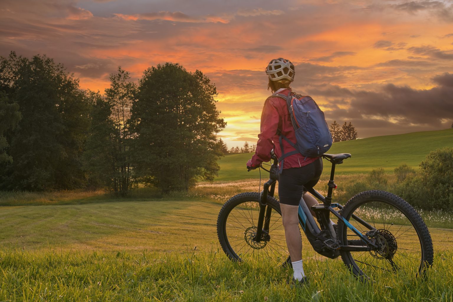 woman with electric bicycle  at sunset in Austria